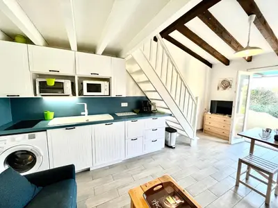 a kitchen with white cabinets and a table at Appartement Studio Porticcio Paesolu 313 in Porticcio