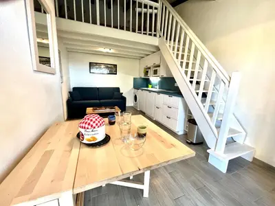 a dining room with a table and a staircase at Appartement Studio Porticcio Paesolu 313 in Porticcio