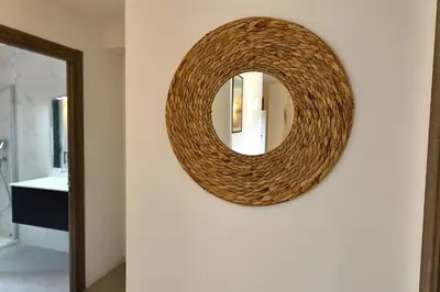 a round mirror on a wall in a hallway at Le Shetland - T4 spacieux bord de mer et piscine in Pianottoli-Caldarello