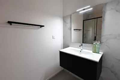 a white bathroom with a sink and a mirror at Le Shetland - T4 spacieux bord de mer et piscine in Pianottoli-Caldarello