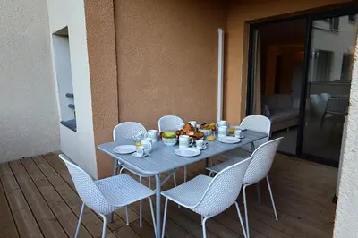 a blue table with white chairs and food on it at Le Shetland - T4 spacieux bord de mer et piscine in Pianottoli-Caldarello
