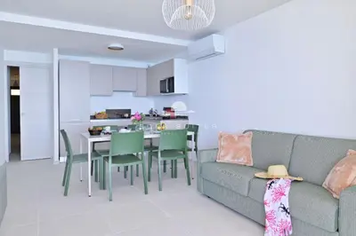 a living room with a couch and a table and chairs at Résidence Eden Suites in Ajaccio
