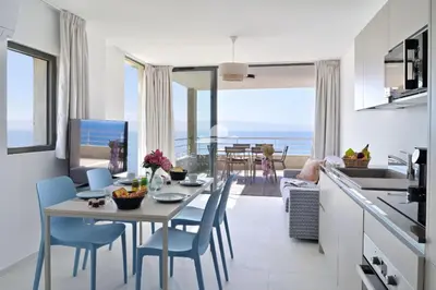 a kitchen and dining room with a table and chairs at Résidence Eden Suites in Ajaccio