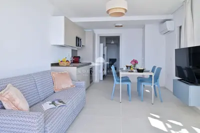a living room with a couch and a table with chairs at Résidence Eden Suites in Ajaccio