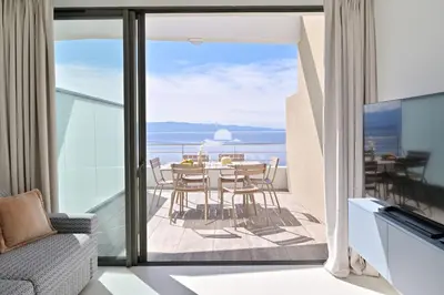 a room with a balcony with a table and chairs at Résidence Eden Suites in Ajaccio