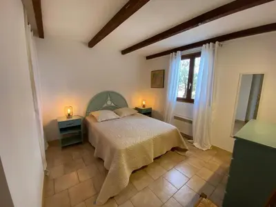 a bedroom with a bed and two tables and a window at L'Olivella in Lama