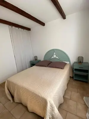a bedroom with a bed with two night stands and two tables at L'Olivella in Lama