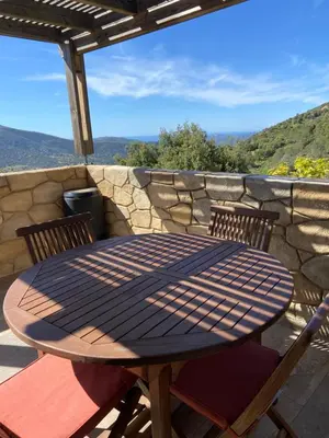a table and chairs on a patio with a stone wall at L'Olivella in Lama