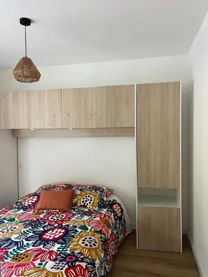 a bedroom with a bed and a wooden cabinet at Casa PANGRANI in Ajaccio