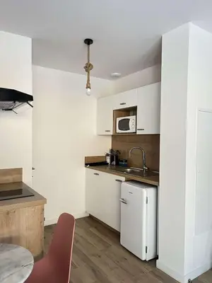 a kitchen with white cabinets and a sink and a table at Casa PANGRANI in Ajaccio