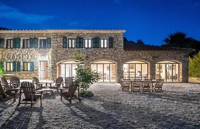 a stone building with tables and chairs in front of it at La tonnelerie, belle villa pour 9 personnes au coeur d'un vignoble avec piscine in Sartène