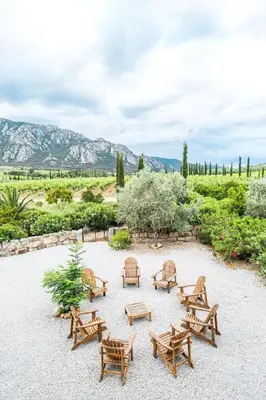a group of wooden benches and tables in a field at La tonnelerie, belle villa pour 9 personnes au coeur d'un vignoble avec piscine in Sartène
