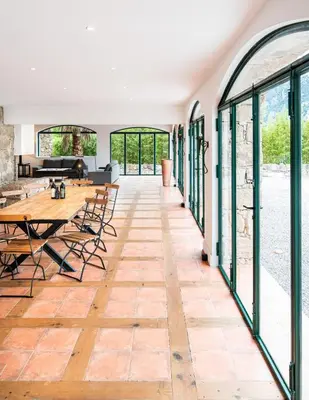 a room with a table and chairs and windows at La tonnelerie, belle villa pour 9 personnes au coeur d'un vignoble avec piscine in Sartène
