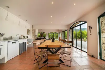 a kitchen with a large wooden table and chairs at La tonnelerie, belle villa pour 9 personnes au coeur d'un vignoble avec piscine in Sartène