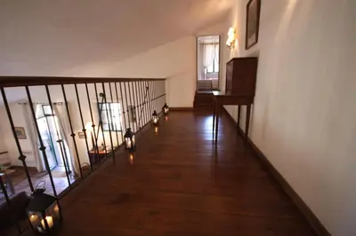 a hallway with a wooden floor and stairs with lights at Les anciennes écuries, belle villa pour 12 personnes au coeur d'un vignoble avec piscine in Sartène