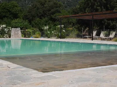 a swimming pool with blue water in a yard at Les anciennes écuries, belle villa pour 12 personnes au coeur d'un vignoble avec piscine in Sartène