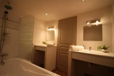 a bathroom with a tub and a sink and a mirror at Les anciennes écuries, belle villa pour 12 personnes au coeur d'un vignoble avec piscine in Sartène