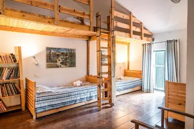 two bunk beds in a room with a book shelf at Le chai, belle villa pour 13 personnes au coeur d'un vignoble avec piscine in Sartène