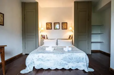 a bedroom with a bed with two towels on it at Le chai, belle villa pour 13 personnes au coeur d'un vignoble avec piscine in Sartène