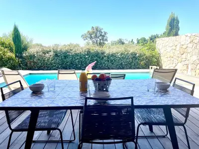 a blue table with chairs and a table and a pool at Villa Mare piscine et spa in Zonza