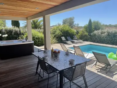 a patio with a table and chairs next to a swimming pool at Villa Mare piscine et spa in Zonza