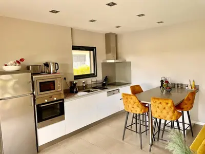 a kitchen with a table and chairs in it at Villa Mare piscine et spa in Zonza