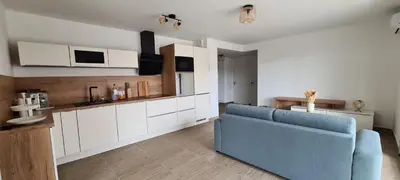 a living room with a blue couch in a kitchen at Appartement 4 pers en résidence in Propriano