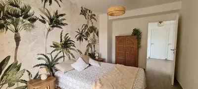 a bedroom with a bed with plants on the wall at Appartement 4 pers en résidence in Propriano