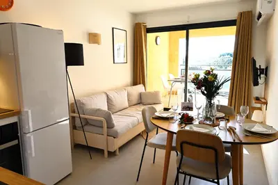 a living room with a couch and a table at Le Loria - T3 vue mer avec piscine in Pianottoli-Caldarello