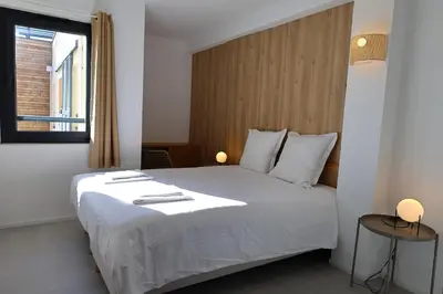 a bedroom with a white bed and a window at Le Loria - T3 vue mer avec piscine in Pianottoli-Caldarello