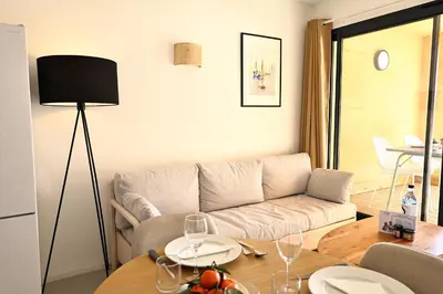 a living room with a couch and a table at Le Loria - T3 vue mer avec piscine in Pianottoli-Caldarello