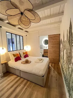a bedroom with a large bed with a ceiling fan at Appartement citadelle Bonifacio Appolonie in Bonifacio