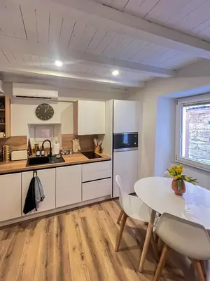 a kitchen with a table and chairs and a kitchen with white cabinets at Appartement citadelle Bonifacio Appolonie in Bonifacio