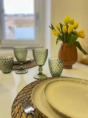 a table with a plate and a vase with yellow flowers at Appartement citadelle Bonifacio Appolonie in Bonifacio