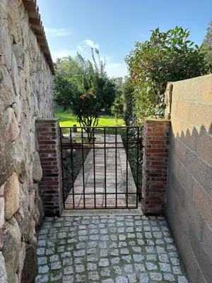 a gate in a brick wall with a stone wall at Bergerie CASEDDU U CHJASSU in Viggianello