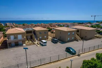 an aerial view of a city with houses and the ocean at Résidence hôtelière D'Amare in Cervione