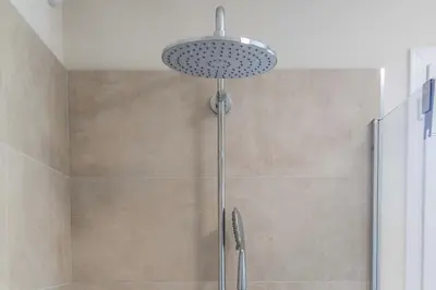 a shower with a shower head in a bathroom at Résidence hôtelière D'Amare in Cervione
