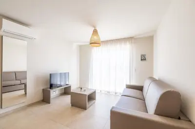 a living room with a couch and a television at Résidence hôtelière D'Amare in Cervione