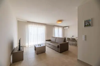 a living room with a couch and a television at Résidence hôtelière D'Amare in Cervione