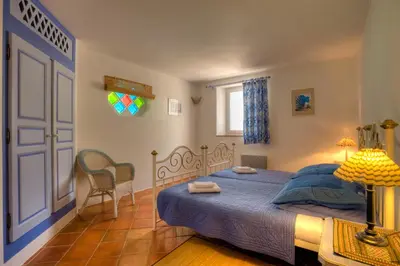 a bedroom with a bed and a table and a door at Chambres d'Hôtes Littariccia in Porto-Vecchio