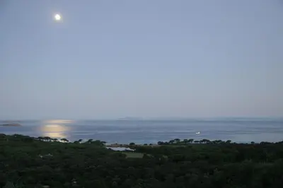 a view of the ocean with the moon in the sky at Chambres d'Hôtes Littariccia in Porto-Vecchio