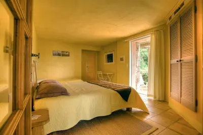 a bedroom with a bed and a large window at Chambres d'Hôtes Littariccia in Porto-Vecchio