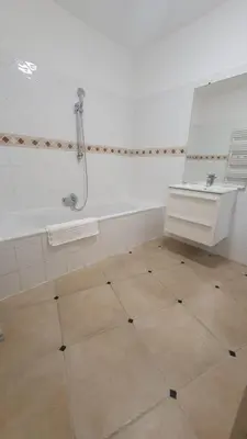 a bathroom with a bath tub and a mirror at Villa eden blue F4 3 in Zonza
