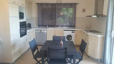 a kitchen with a table and chairs and a kitchen with a stove at Villa eden blue F4 3 in Zonza