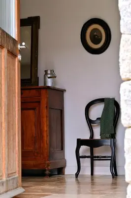 a black chair sitting in a room with a mirror at Les bergeries alivaccia in Figari