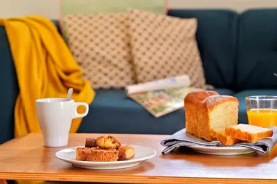 a table with two plates of bread and a cup of orange juice at Les bergeries alivaccia in Figari