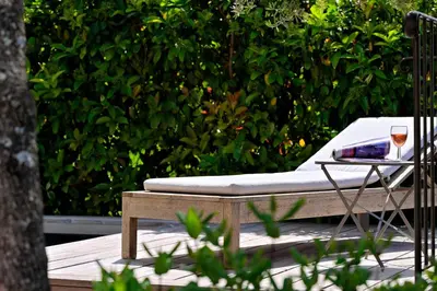 a bed and a table with a glass of wine at Les bergeries alivaccia in Figari