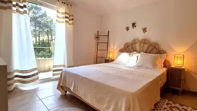 a bedroom with a large bed and a large window at Appartement Ruscana, 4 pers, 90 m plage in Pinarellu