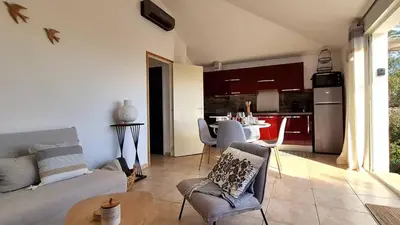 a living room with a couch and chairs and a kitchen at Appartement Ruscana, 4 pers, 90 m plage in Pinarellu