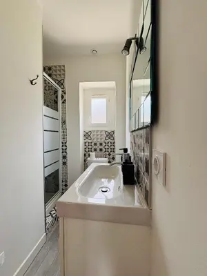 a white bathroom with a sink and a mirror at Straboni corte in Corte